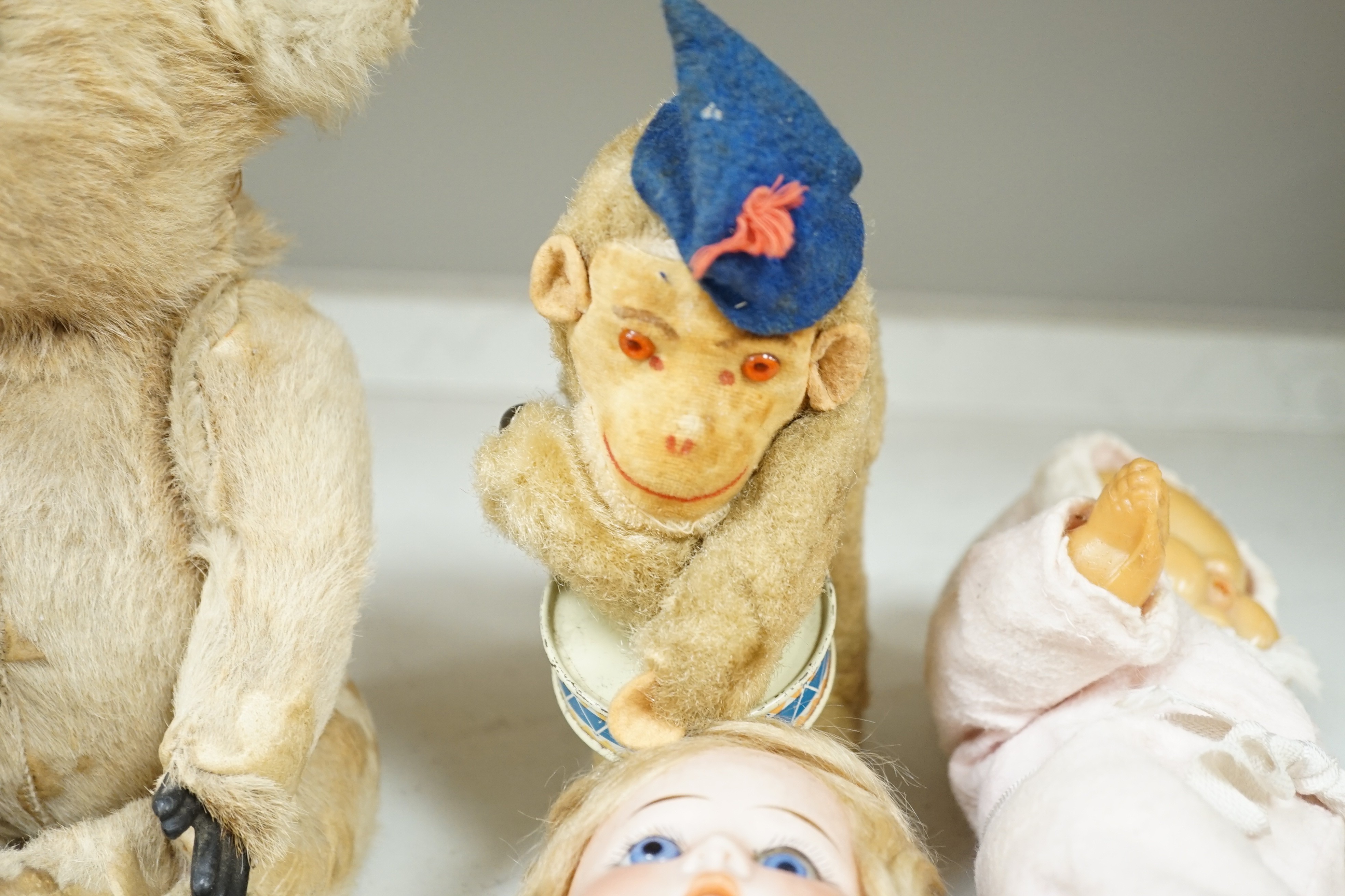 Two Chad Valley felt soldier dolls with glass eyes, a German bisque head doll, a rubber doll and a wind up monkey